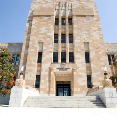 A phot of the main entrance to UQ's Forgan Smith sandstone building on a sunny day. 